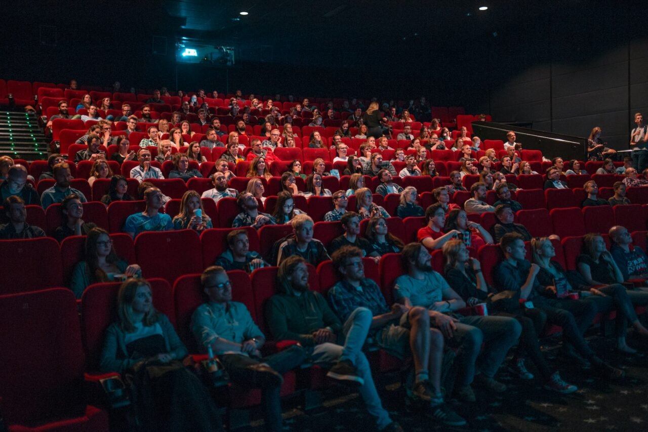 pessoas assistindo nas poltronas do cinema
