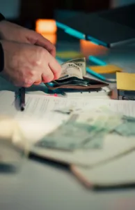 Hands counting money over papers and around papers