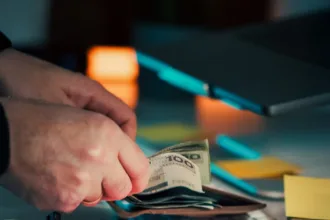 Hands counting money over papers and around papers